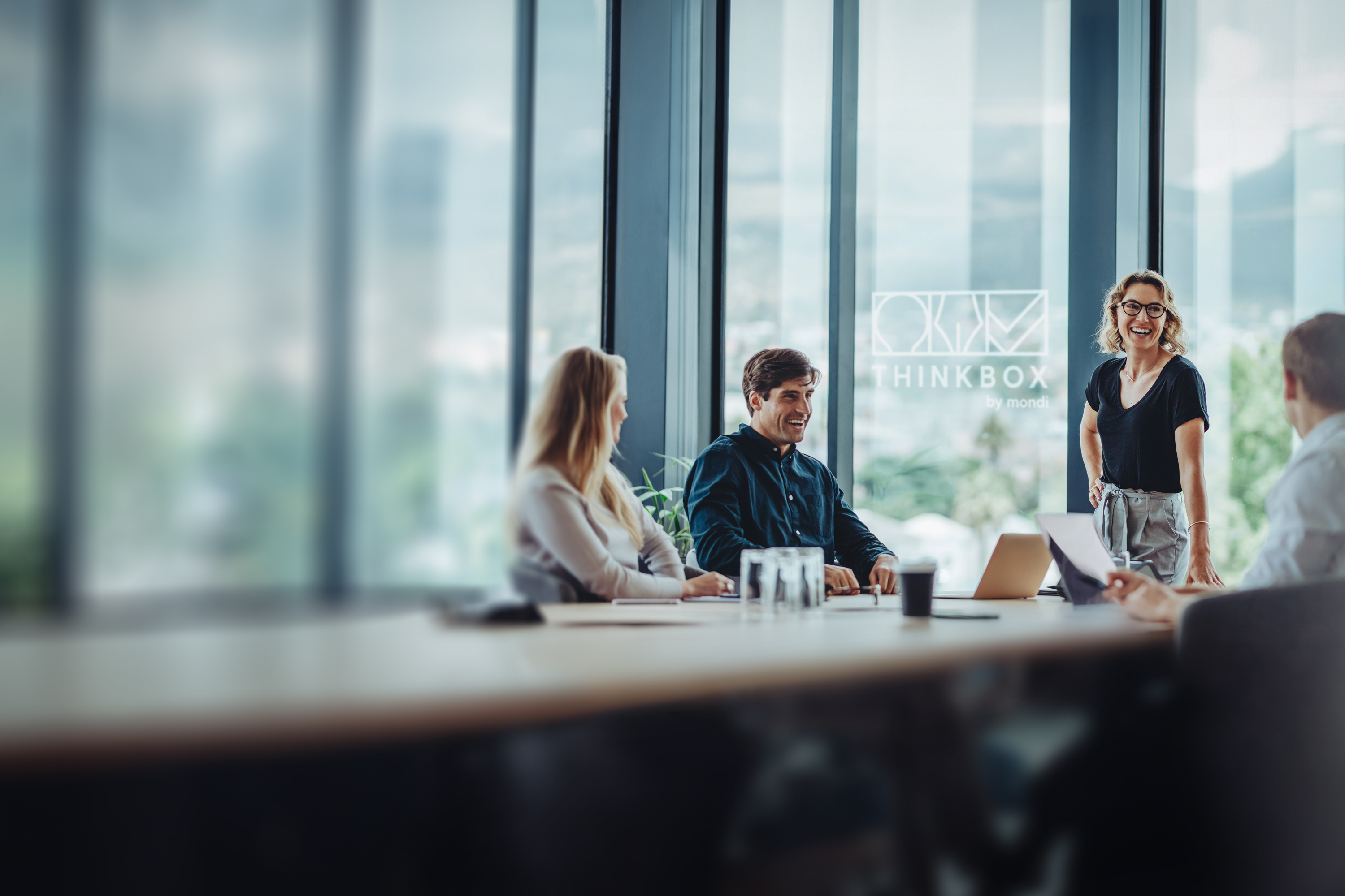 Grupa osób prowadząca rozmowę przy stole w wirtualnej przestrzeni ThinkBox.