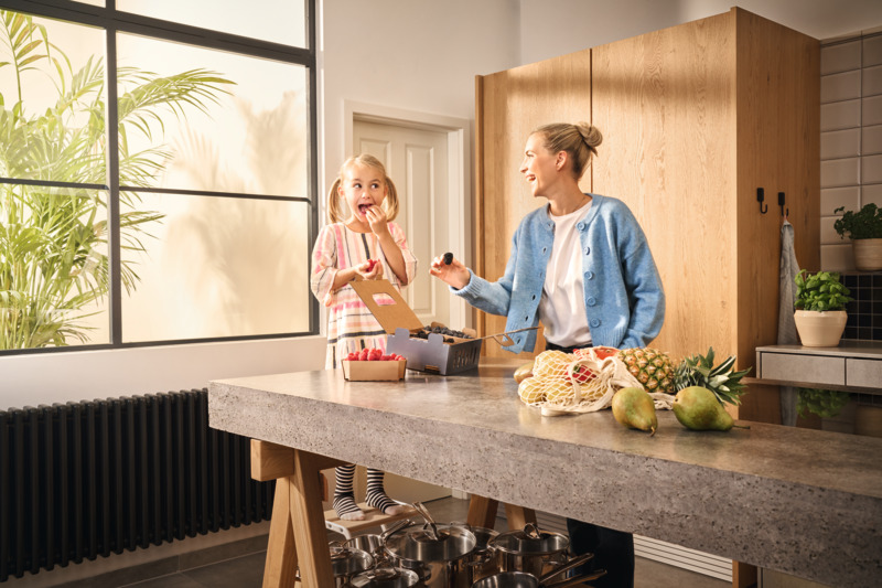 Kobiety stojące przed wybranymi owocami w kartonowych pudełkach, kupujące owoce. 