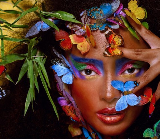 Kobieta otoczona kolorowymi liśćmi i motylami.